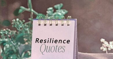 A note pad with the words "Resilience quotes" on the visible page. It sits on a tree stupm with a plant behind it.