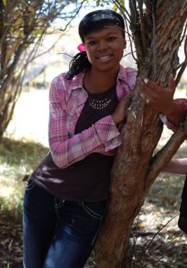 A photo of Lily as a teenager leaning against a tree while she lived in foster care.
