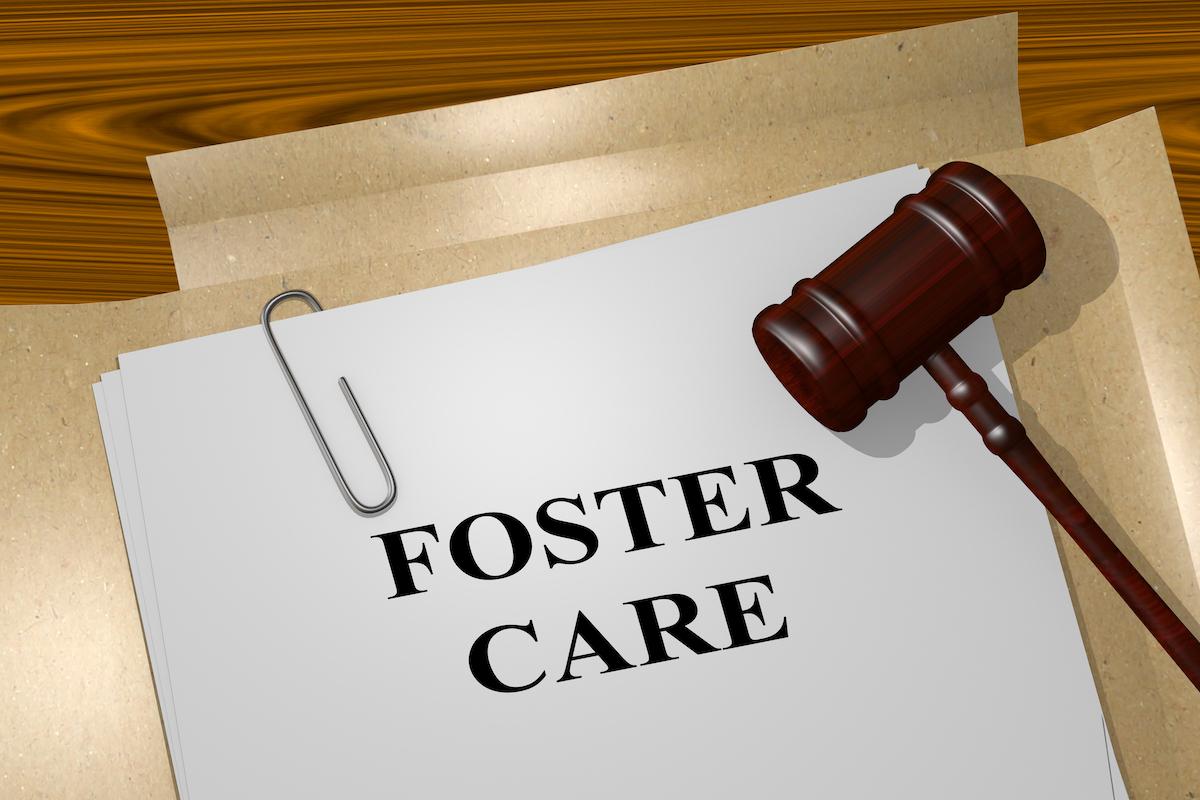 'Foster Care' printed on a legal document with a judge's gavel resting on top.