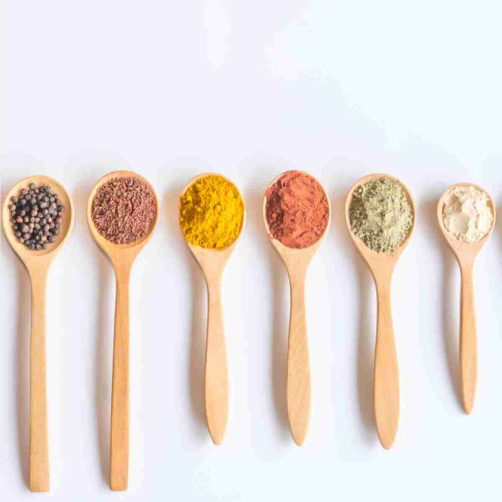 Wooden spoons full of colorful spices and seed depicting micronutrients for nutritional psychiatry