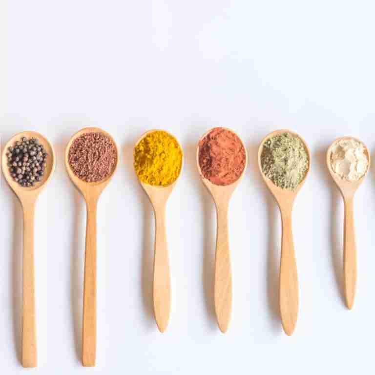 Wooden spoons full of colorful spices and seed depicting micronutrients for nutritional psychiatry