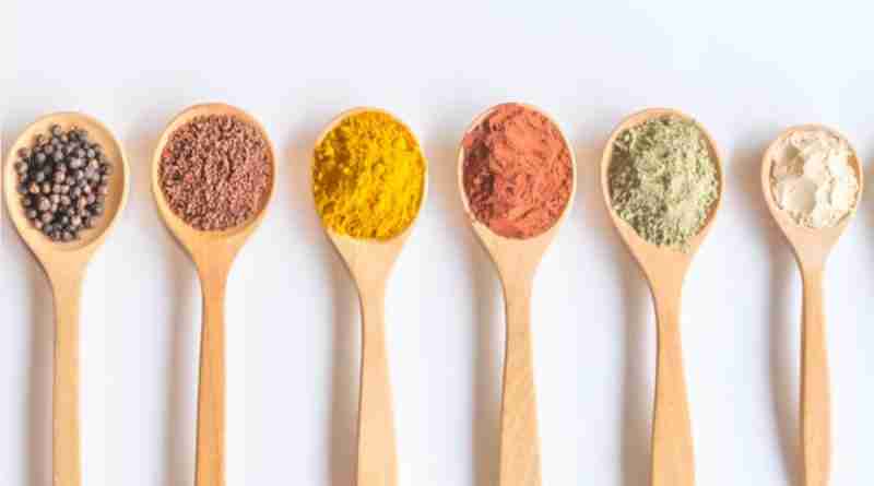 Wooden spoons full of colorful spices and seed depicting micronutrients for nutritional psychiatry