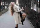A woman dancing in the street with a cup of coffee in her hand. She is celebrating the no career life and rejecting family expectations.