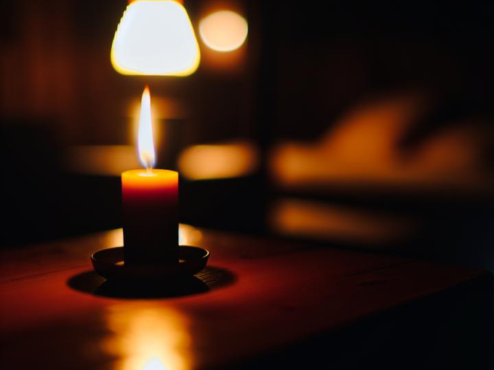 A candle illuminating a dark room, symbolizing the journey from darkness to light.