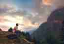 Man sitting on a mountainside looking at a clouds covering the adjacent mountain. Photo by Arijit Chakraborty from Pixabay