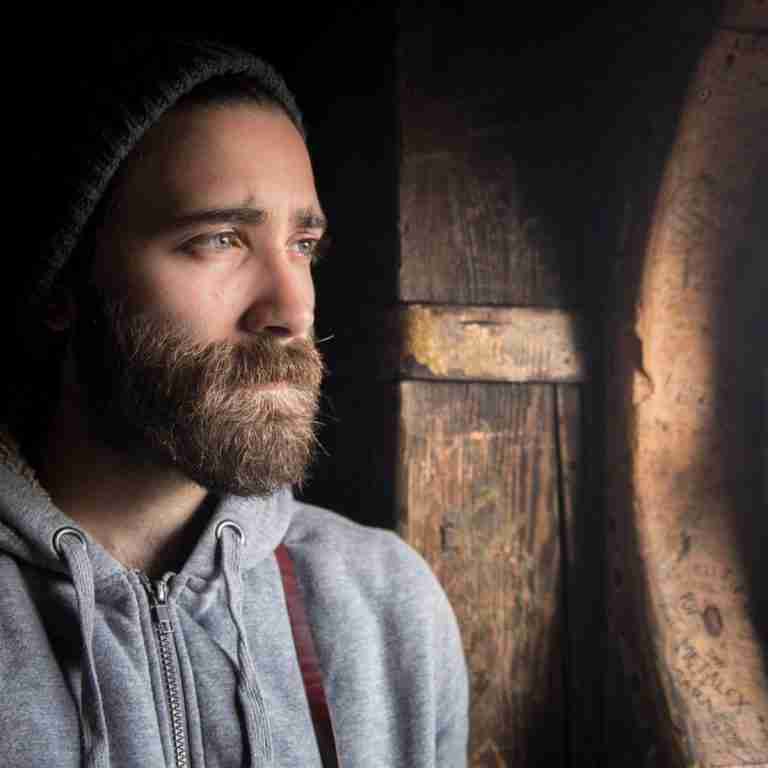 Photo of guy in beaning looking sadly out window