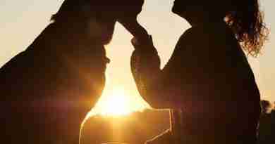 Photo of woman and dog silhouetted against setting sun. Photo by lokalsportessen from Pixabay