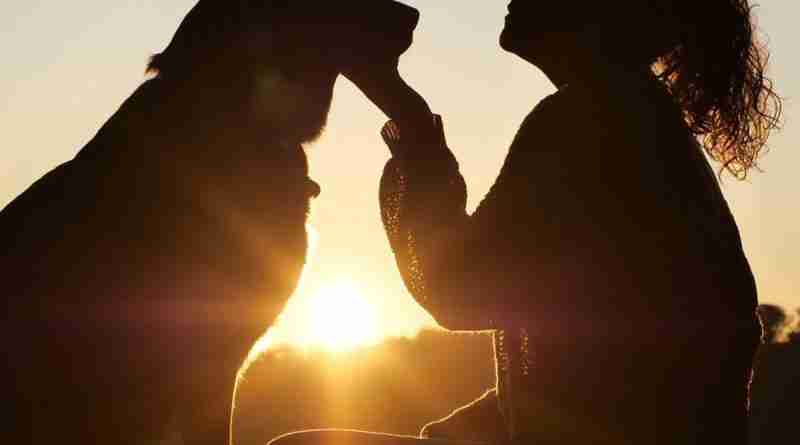 Photo of woman and dog silhouetted against setting sun. Photo by lokalsportessen from Pixabay