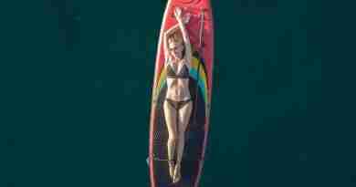 Girl laying on paddle board in middle of ocean. Image by Alexey Komissarov from Pixabay