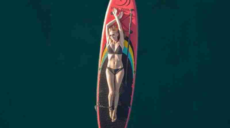 Girl laying on paddle board in middle of ocean. Image by Alexey Komissarov from Pixabay