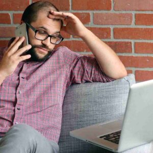 Photo of man on the phone in front of his computer looking frustrated. Image by Steve DiMatteo from Pixabay