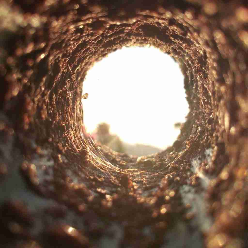 Photo of inside of a dirt tunnel leading to the outside light