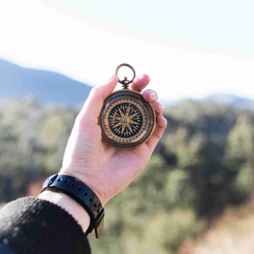 Photo of a hand holding up a compass. Image by Pexels from Pixabay