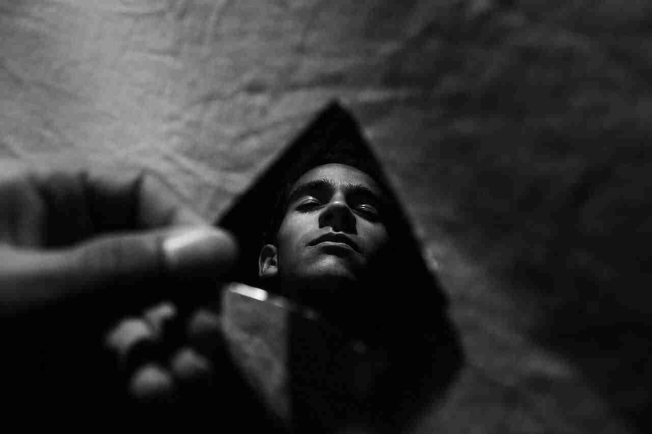 Man reflecting his face in a broken mirror depicting the broken feeling from crippling depression