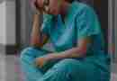 AI-generated image of a nurse sitting on floor, head in hand, feeling run down. Image by Gerd Altmann from Pixabay