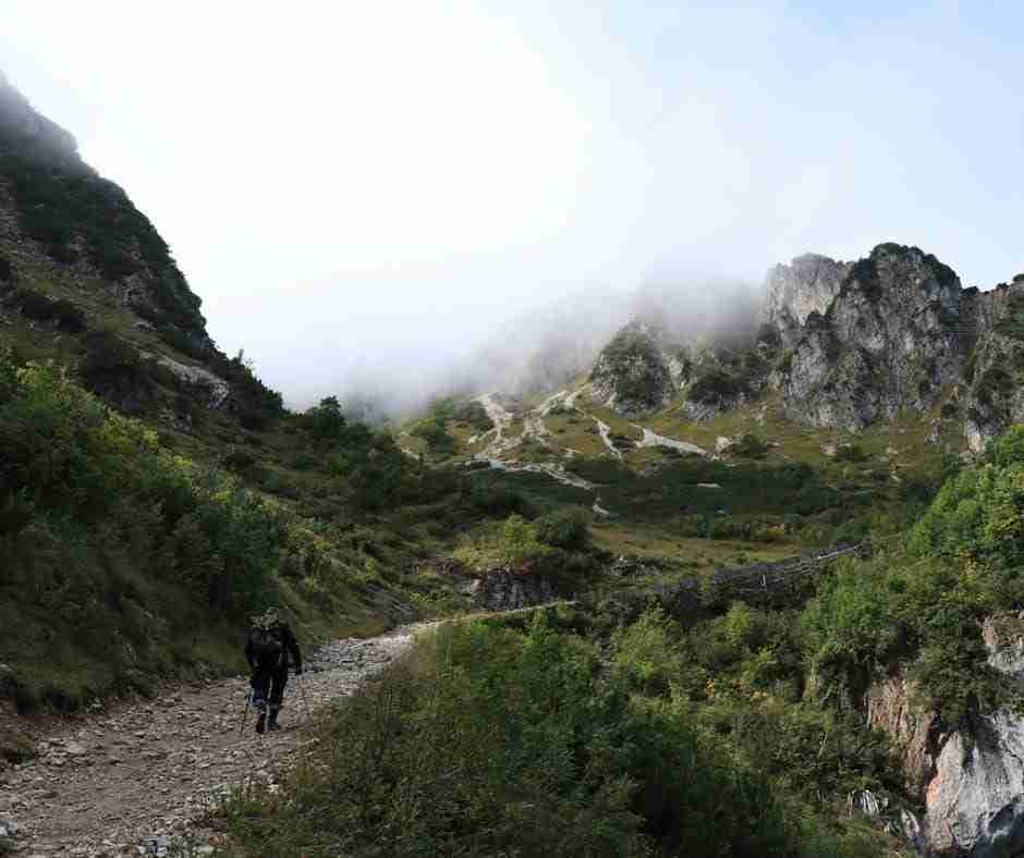 Untitled design (25) - Resilient Stories Photo of a man climbing a mountain path into the clouds.