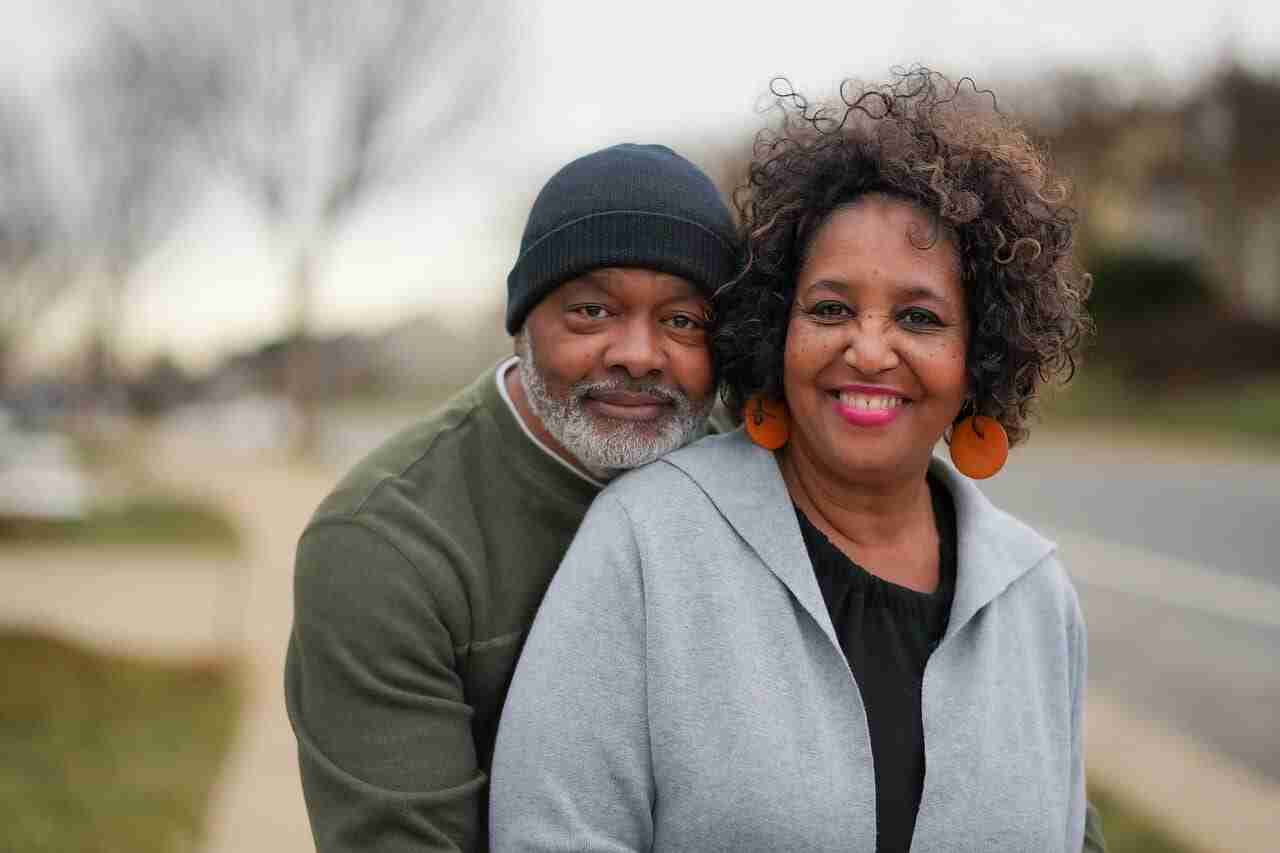 Older African-American couple embracing and looking happy.