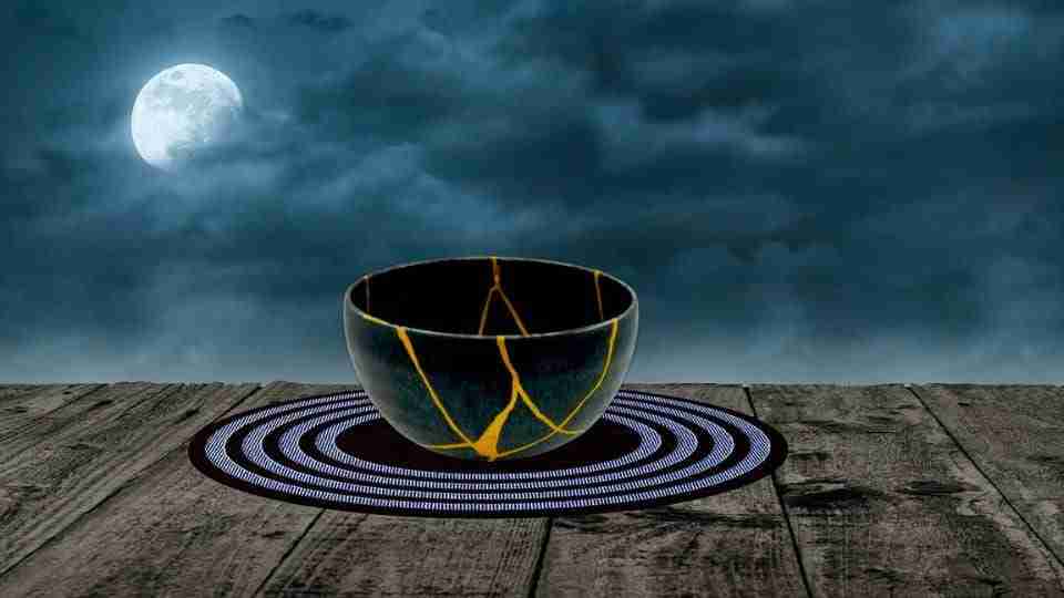 Untitled-design-2024-05-19T185506.158 - Resilient Stories Kintsugi repaired bowl sitting on table under cloud, full moon sky