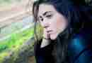 Photo of girl sitting outside looking sad and pensive. Photo by Kyle Broad on Unsplash