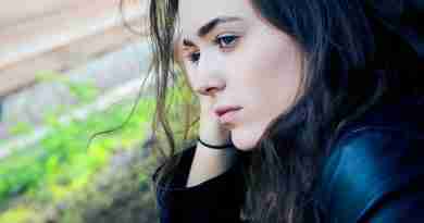 Photo of girl sitting outside looking sad and pensive. Photo by Kyle Broad on Unsplash