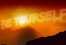 Sunset over mountains with words in the sky that say "be yourself"