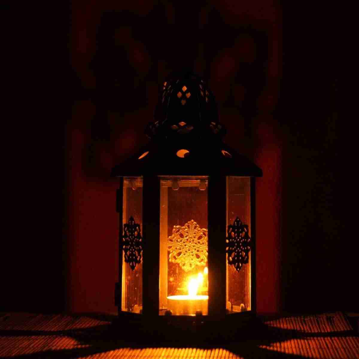 Photo of decorative lantern with candle burning inside. 
