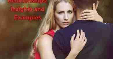 A woman wearing a red dress hugs a man whose back is facing the camera. She is looking right at the camera as if something is going on.