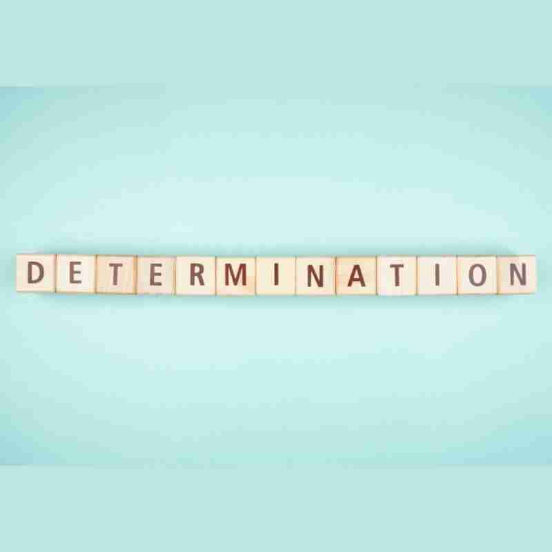 The emotion word "determination" is spelt on Scrabble tiles.