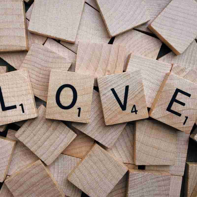 The emotion word love is spelt out on Scrabble tiles.
