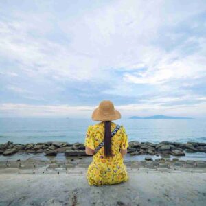 Girl on beach in yellow dress and hat. Image by Thuan Vo from Pixabay