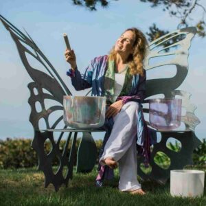 A photo of the author with her sound bowls demonstrating the power of sound.