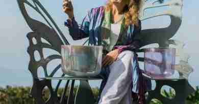 A photo of the author with her sound bowls demonstrating the power of sound.