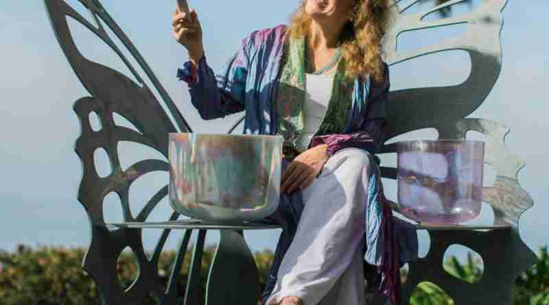 A photo of the author with her sound bowls demonstrating the power of sound.