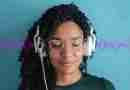 Woman with eyes closed and headphones on, looking tranquil listening to 396 Hz frequency