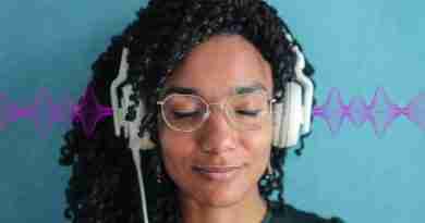 Woman with eyes closed and headphones on, looking tranquil listening to 396 Hz frequency