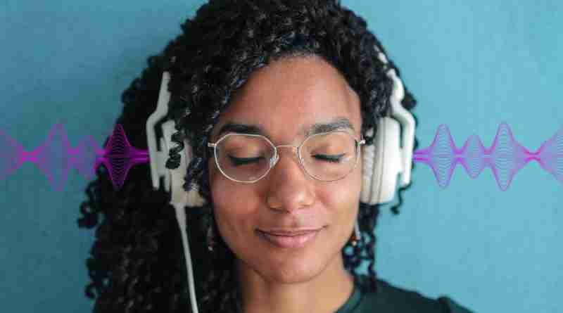 Woman with eyes closed and headphones on, looking tranquil listening to 396 Hz frequency