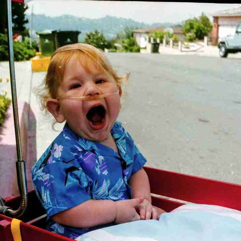 Eric being pulled in his wagon as a toddler.