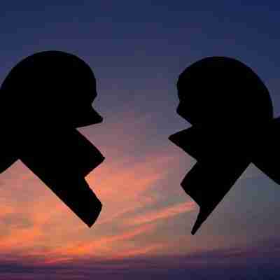 Image of broken heart silhouette against a pink and purple sunrise sky.