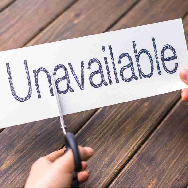 The word unavailable is written on a piece of paper and someone is cutting off the "un."