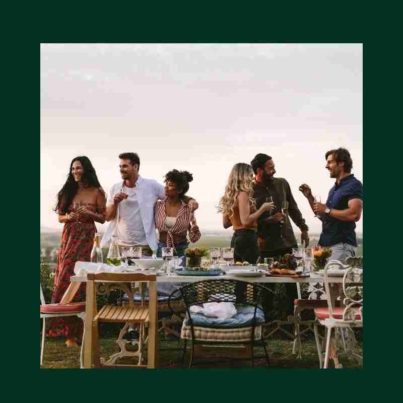 A group of people hanging out near the beach drinking champagne having a divorce party.