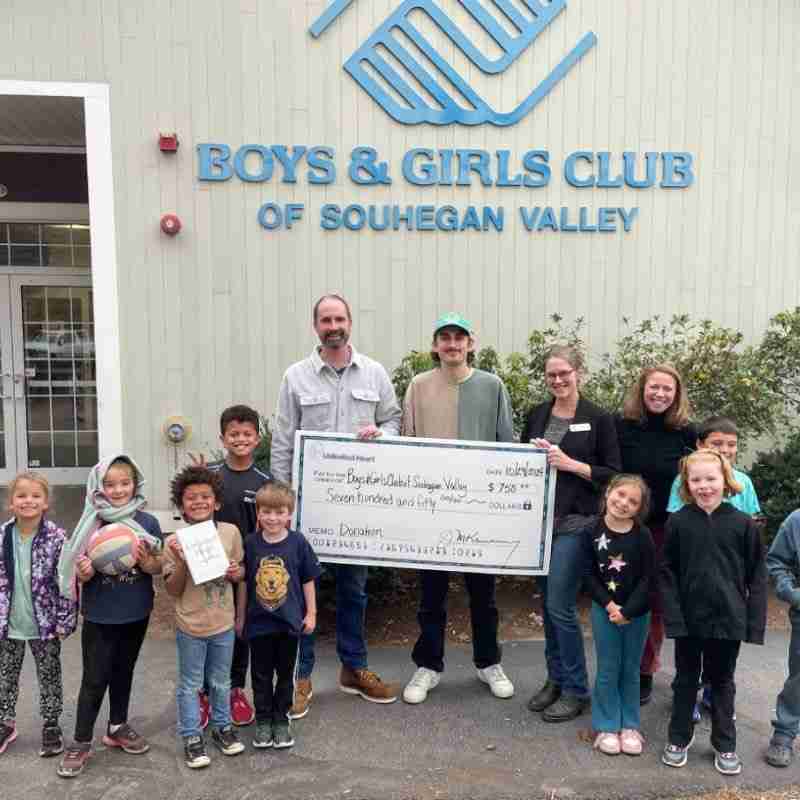 A photo of Jim giving a donation to the Boys & Girls Club.