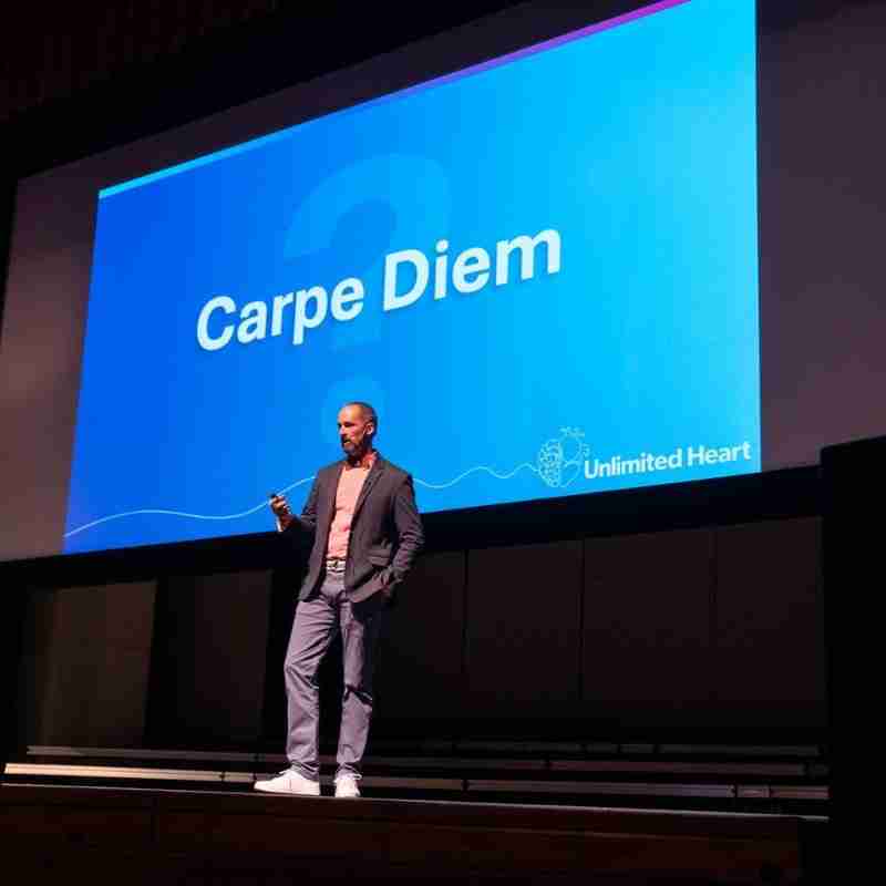 A photo of Jim giving a presentation based on his book: Unlimited Heart.