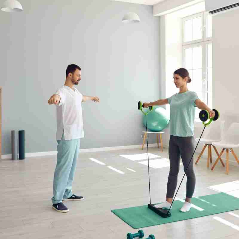 A woman works with a male physical therapist on movement and simple workouts that can help you increase movement after physical trauma.