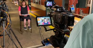 A photo of Bernie being interviewed after transitioning from the male voice behind the NYC subway.