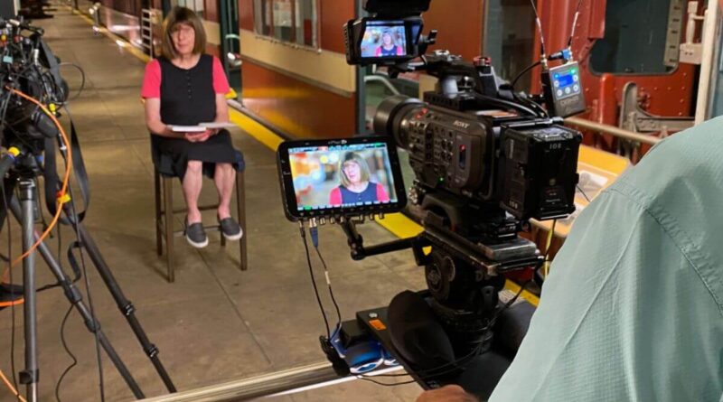 A photo of Bernie being interviewed after transitioning from the male voice behind the NYC subway.