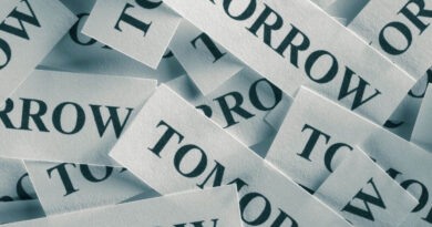 Tiny slips of paper with the word tomorrow printed on them and piled together.