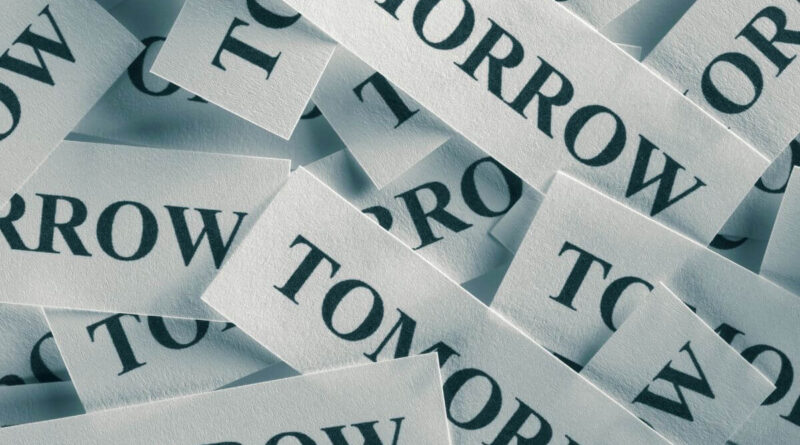 Tiny slips of paper with the word tomorrow printed on them and piled together.