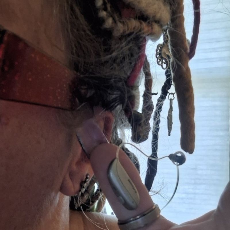 A photo of the author, who has impaired hearing, and her hearing aid is stuck in her hair.