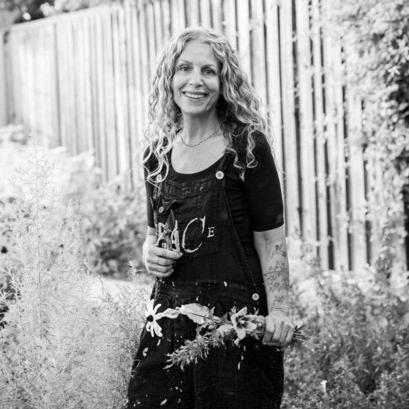 A photo of the author, Dina Saalisi in her garden, years after the score that changed her life.