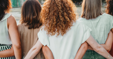 A group of women link hands behind their back. It symbolizes Clementine's lifelong mission of understanding what finding community means.